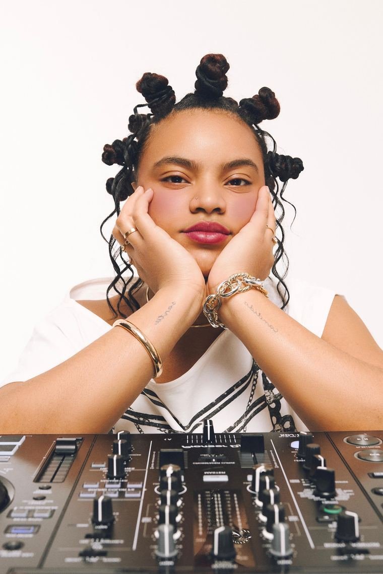 Sheryna DJ en cabina con luces de club